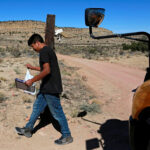 person carrying textbook in New Mexico desert