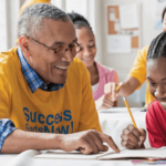 older African American man studying with African American youth